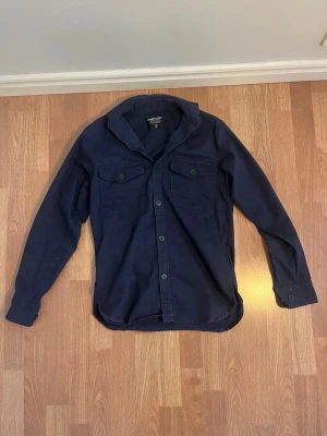 Mörkblå Overshirt Från Sams Black - Säljer nu en mörkblå overshirt från Sams Black i storlek XS men sitter som S. Riktigt snygg med två bröstfickor och knappar. Riktigt snygg passform och utan defekter. Tveka inte på att höra av dig ifall du undrar något!✨