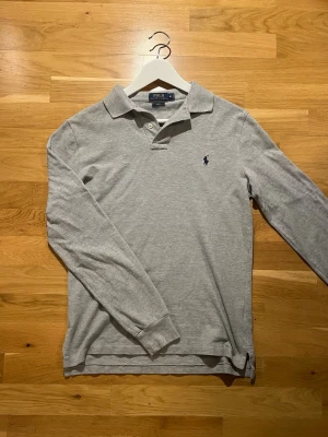 Ralph Lauren - Grå Piké - Klassisk Ralph Lauren piké | Storlek: M, Slim Fit | Skick: Mycket bra | Autentisk | Kom privat vid frågor, allt gott |