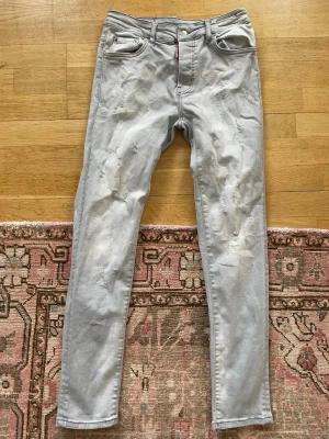 Ljusgrå jeans från Levi's - Snygga ljusgrå jeans från Levi's med raka ben och diskreta slitningar framtill. Klassisk femficksmodell med knapp- och dragkedjegylf. Perfekta för en avslappnad och trendig look.