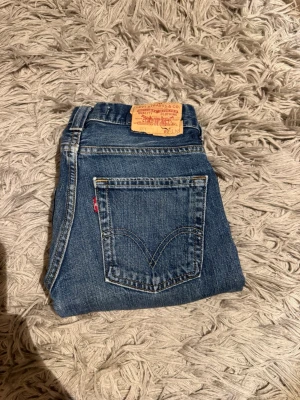 Levi’s 511 jeans - Säljer ett par klassiska blå Levi's jeans med raka ben och femficksdesign. Jeansen har den ikoniska läderpatchen bak i midjan och röd Levi's-tagg på bakfickan. Tillverkade i slitstark denim som ger en tidlös look. Storleken är W31 L32. Pris kan diskuteras vid snabb affär. Bara att höra av sig vid minsta fundering!
