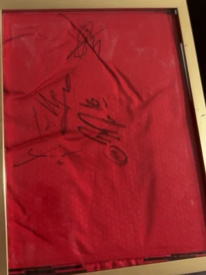 Röd signerad fotbollströja Hertha BSC - Röd fotbollströja från Hertha BSC med svarta detaljer och svart/vitt 'wefox'-tryck på nedre delen. Signad tröja av modric Mike Mignan pavlovic och Allegri bevis finns med video och bild. Perfekt för fans och samlare.