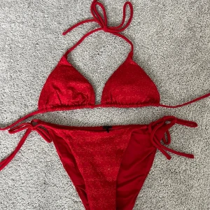 röd bikini med broderat mönster - Såå snygg röd bikini med blommönster och knytband❣️Köpt här på Plick men aldrig använd då den var för liten, före detta säljare hade aldrig heller använt den pga fel storlek