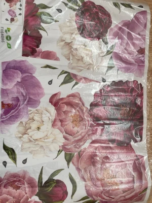 Blommiga dekorationsstickers - Säljer ett ark med dekorationsstickers med stora blommotiv i lila, vinrött och vitt. Perfekt för att piffa upp väggar, möbler eller andra ytor. Motiven är detaljerade och har gröna blad. Materialet är plast.