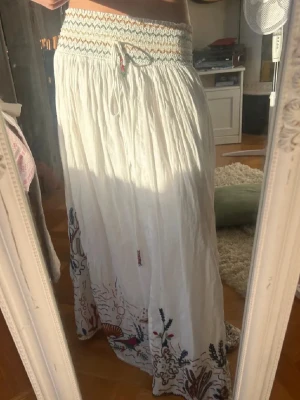 Lång kjol från Zara 🤍 - Säljer den virala vita långkjol med broderi. SLUTSÅLD och finns ej att köpa längre på Zara. Köpt för 600 kr. Har aldrid använts och har prislapp kvar. Storlek Xs men funkar som S, väldigt strechigt.