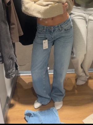 Jeans - Säljer ett par ljusblå jeans i med rak modell och låg midja. Jag har klippt upp några cm på varje ben längst ner för att få ett trendigare utseende, men jag har oxå sänkt priset lite pågrund av de 