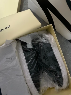 Svarta sneakers från Axel Arigato Clean Sued 90 Strl 44 - Stilrena svarta sneakers från Axel Arigato med vit sula. Klassisk låg modell i läder, levereras i originalkartong med dustbag. Perfekta för dig som gillar minimalistisk och modern design. Endast använt 1 gång, allt ingår. STORLEK 44. Pris går att diskutera