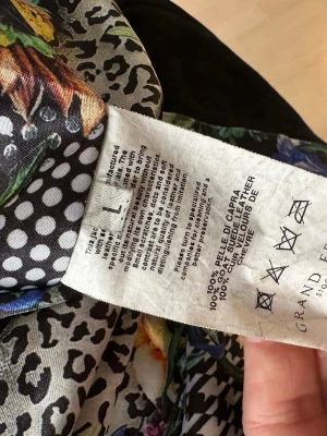 Mönstrad mocka jacka Grand Frank - Unik jacka från Grand Frank Suede Collection, tillverkad i Italien. Kappan är i 100% getmocka och har ett färgstarkt mönster med blommor, prickar och djurprint i svart, vitt, grönt och orange. Passar till jeans, kostymbyxor, skjorta och tisha. Perfekt till våren! 