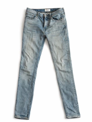 Jeans Jack & Jones - Säljer ett par ljusblå skinny jeans från Jack & Jones med klassisk look. Jeansen har en tvättad look och smal passform som sitter tight längs benen. Perfekt för en mer ”grishig” stil för en billigare peng. W27 /L 30