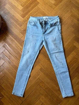Ljusblå skinny jeans från Redial - Säljer ett par ljusblå skinny jeans från Redial Premium Denim Collection. Jeansen har klassisk femficksdesign, hög midja och smal passform hela vägen ner. Tillverkade i mjuk denim med stretch för extra komfort.