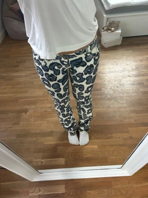 Leopardmönstrade jeans från Lee - Säljer ett par unika jeans från Lee med blått och svart leopardmönster på vit botten. Modellen har klassisk femficksdesign och lite utsvängda nedtill. (W 83cm, innebenslängd 80cm). Skriv för frågor💕