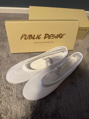 Vita ballerinaskor🤍 - Säljer ett par stilrena och bekväma ballerinaskor från Public Desire. Skorna är helt nya och aldrig använda, endast provade hemma. De kommer fortfarande i originalkartongen. Storlek 40/41🤍 Skorna har en fin vit mesh-design och vit ”spets” som gör dem både luftiga och moderna. Perfekta till både vardag, sommaroutfits eller när du vill ha något lätt och bekvämt på fötterna. Köp nu inför vår!💐💞💞