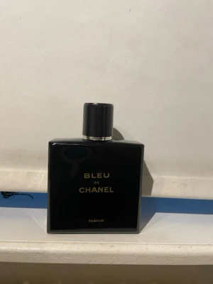 Bleu de Chanel Parfum - Snygg och lyxig parfym från Chanel, Bleu de Chanel Parfum. Flaskan är fyrkantig och djupblå med guldfärgad text och svart lock. Perfekt för dig som gillar exklusiva dofter och stilren design. 85ml 