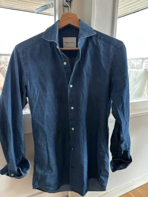 Blå skjorta från A Day's March - Säljer en stilren blå skjorta från A Day's March i mjuk bomull. Skjortan har klassisk krage (kragstorlek 37), är i fint skick. Priset är inte hugget i sten