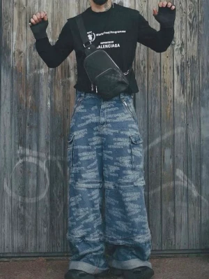 Vetements All-Over Logo Transformer Cargo Jeans - Säljer ett par riktigt baggy cargobyxor från Vetements i blå denim med all-over logoprint. Byxorna har flera stora fickor på sidorna och bred passform för en avslappnad streetwear-look. Perfekta för dig som gillar statement-plagg och vill sticka ut.