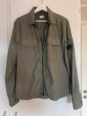 Olivgrön overshirt från C.P. Company - Overshirt från Cp Company. Nypris ligger på 4500 kr. Storlek S. Samtliga lappar från inköpet på Ströms finns kvar. Hör av er vid frågor. Kan gå ner i pris vid snabb affär.