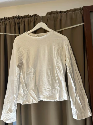 Vit långärmad topp från H&M - En basic vit långärmad topp från H&M. Enkel och stilren design med rund halsringning och normal passform. Storlek S. Köparen står för frakt 