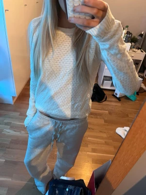 Vit stickad tröja - Säljer en vit stickad tröja med rund hals. Tröjan har långa ärmar och en avslappnad passform, perfekt till ett par jeans!!