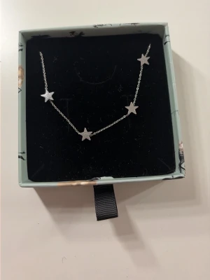 Silverfärgat armband med stjärnor - Snyggt armband i silverfärg med små stjärnberlocker på en tunn kedja. Perfekt för dig som gillar minimalistisk och trendig stil. Armbandet har en enkel och stilren design som passar till många olika looks. Från Edblad 