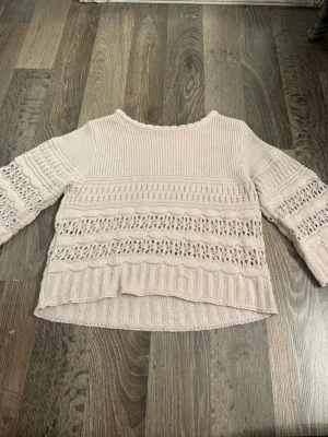 Ljusrosa stickad tröja med mönster - Säljer en ljusrosa stickad tröja med breda trekvartsärmar och fina virkade detaljer. 