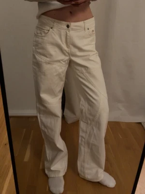 Vida vita jeans från Nakd - Säljer ett par vita jeans från Nakd med bred passform och raka ben. Jeansen har synliga sömmar och en klassisk knappgylf. Materialet är denim och de har en avslappnad, trendig look.
