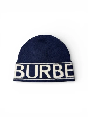 Mörkblå Burberry mössa - Säljer en mörkblå stickad mössa från Burberry med bred vit kant och stor logotyp i vitt runt om. Klassisk beanie-modell i mjukt material som sitter skönt på huvudet. Perfekt för dig som vill ha en stilren accessoar med tydlig logga.