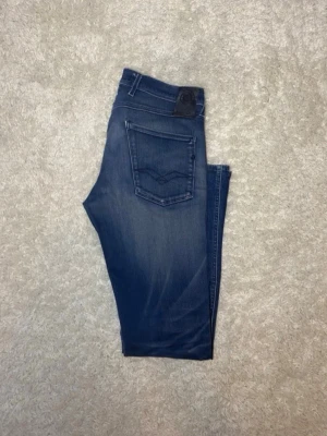 Replay Anbass Jeans - Säljer ett par lite schysstare REPLAY Jeans i storlek 31/34 i slim fit. Ett litet ihopsytt hål som fortfarande håller efter användning se bild 5. Skriv vid frågor eller om ni vill ha mer bilder