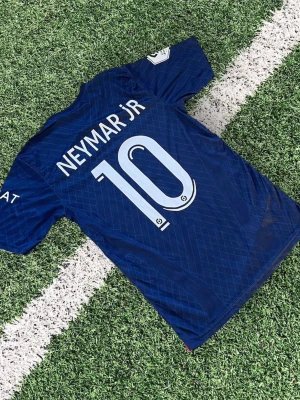PSG Neymar Jr #10 Hemmatröja 23/24 – Strl S – Toppskick - • Paris Saint-Germain hemmaställ • Neymar Jr #10 på ryggen • Storlek S • Nike Dri-FIT (skön & lätt i materialet) • Snyggt skick – inga synliga fläckar eller sprickor • Perfekt för match, träning eller streetwear  En av PSG:s snyggaste hemmatröjor med klassiska röd/blå detaljen framtill 🔴🔵 Säljes då den inte används.  Snabb frakt ⚽🔥 
