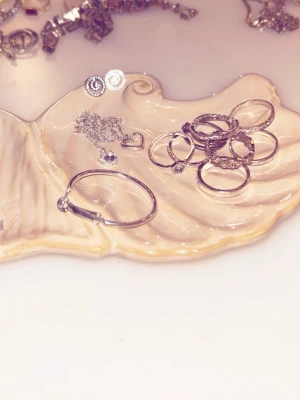 Silverfärgade smycken  - Säljer ett mixat set med silverfärgade ringar, halsband och örhängen i olika former. Perfekt för dig som gillar att variera dina smycken och skapa en personlig stil. Materialet är metall med blank finish och detaljerade mönster. Det är 9 stycken ringar i olika färger för 15, två par fina hjärtformade halsband för 20 kr och spiral örhängen för 5 kr. Alla för 40 kr.  Gå in på mitt konto jag säljer FLERA smycken i olika former och färger. 😊