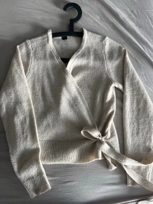 Beige omlottkofta från Esmara - Superfin stickad omlottkofta i en mjuk beige/creme nyans. Modellen är croppad med knyt i sidan som ger en smickrande passform och en feminin silhuett. Perfekt att styla till jeans, kostymbyxor eller över en klänning 🌿 ✨ Storlek: XS (32/34) ✨ Märke: Esmara ✨ Färg: Ljus beige ✨ Skick: Fint skick En tidlös och lättmatchad bas som funkar året runt – lika snygg till vardag som till en mer uppklädd look. 📦 Kan skickas direkt 💌 Hör av dig vid frågor