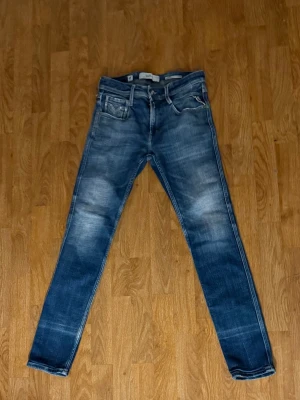 Blå slim fit replay jeans Anbass  - Säljer ett par blå slim fit replay jeans och tvättade detaljer. Jeansen har fem fickor, normal midja och smala ben. Perfekta för en avslappnad och trendig look. Aldrig använda, W28 L 32 men sitter som W29 L30.