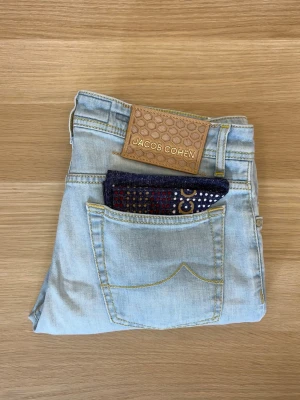 Jacob Cohën Jeans | Bard - Eleganta Jacob Cohën jeans i unik tvätt | W33 | Modell: Bard (tapered fit) | Defekter: Nej, nyskick | Tillbehör: Näsduk | Midja: 44 cm | Längd: 99 cm | Innerbenslängd: 75 cm | Måttavvikelser +-1 cm | Modellen är 175 cm och väger 70 kg | Tveka inte att kontakta mig vid frågor😁