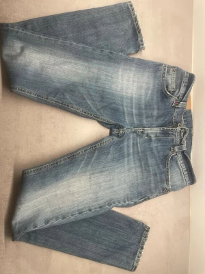 Ljusblå raka jeans från Lee - Snygga ljusblå jeans från dondup med slim ben och klassisk femficksmodell. Jeansen har slitningar och tvättade detaljer för en avslappnad look. Tillverkade i bomull med dondup-logga på bakfickan och läderpatch i midjan. En pytte liten defekt med benet (se sista bilden)
