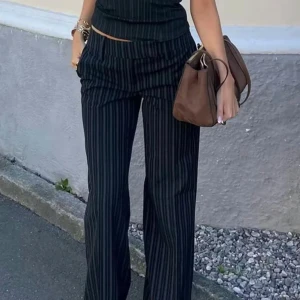 Svarta kostymbyxor med ränder Bik Bok - Säljer ett par svarta kostymbyxor från Bik Bok med tunna vita kritstrecksränder. Byxorna har raka ben och låg midja, vilket ger en snygg och modern siluett. Perfekta att styla med crop top eller skjorta för en trendig look. Prislapp på, helt nya! Slutsålda på hemsidan!!!