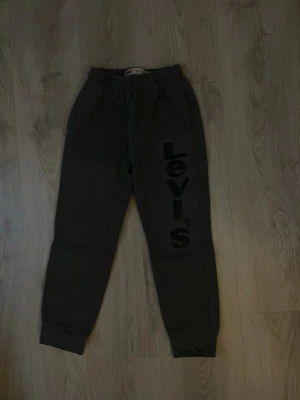 Mörkgrå mjukisbyxor från Levi's - Mörkgrå mjukisbyxor från Levi's med resår i midjan och muddar vid bensluten. Pris kan alltid diskuteras 