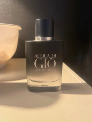 Acqua di Giò Parfum Giorgio Armani - Acqua di Giò Parfum från Giorgio Armani i en stilren, matt svart glasflaska med silverdetaljer. Flaskan har en elegant och modern design med tydlig logotyp framtill. Perfekt för dig som gillar exklusiva och fräscha dofter. Ungefär 40 ml kvar. Skriv vid minsta fråga. Mvh Santino!