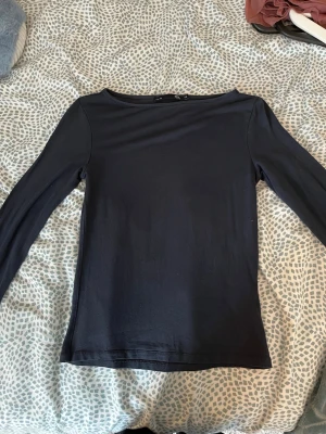 Mörkblå långärmad topp från 157 - En enkel och stilren mörkblå långärmad topp från 157. Modellen har en rundad halsringning och är gjord i mjuk bomull som sitter skönt mot kroppen. Bra skick, men har dock använt den ganska mycket.