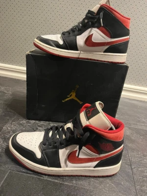 Jordan 1s Mid (Gym Red) - Säljer ett par snygga Jordan 1s Mid Gym Red som är i ett riktigt fint skick 8.5/10. Det finns hål i hällen på skorna men det är inget man tänker på dirket. Priset kan diskuteras vid snabb affär! Hör av er vid minsta frågor eller funderingar! Lådan osv medföljer! 