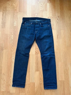Mörkblå straight jeans från Ralph Lauren - Snygga mörkblå jeans från Ralph Lauren Denim & Supply med klassisk femficksmodell och raka ben. Jeansen har en stilren look med subtila sömmar och är tillverkade i kraftig denim. Perfekta för dig som gillar enkel och tidlös stil.