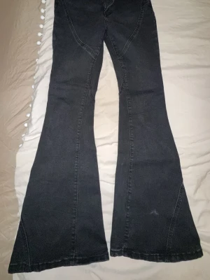 Svarta utsvängda jeans  - Säljer ett par svarta utsvängda jeans från SHEIN. Jeansen har en cool bootcut-modell med markerade sömmar