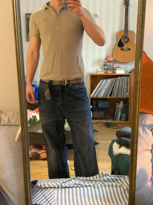 Beige polotopp  - Säljer en beige polotopp. Toppen är kortärmad och har en liten logga på bröstet. Smal passform. 