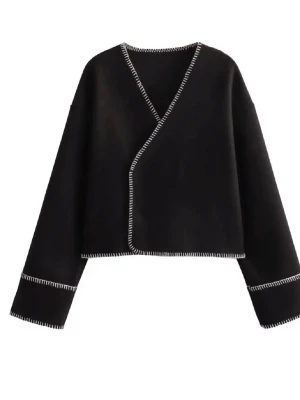 Svart omlottkofta med kontrastsömmar - SITTER SOM M”Snygg svart omlottkofta med vita kontrastsömmar längs kanterna och ärmsluten. Ena knappen är av och andra fungerar ej men kan användas bara på eller som en kofta 