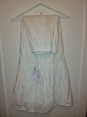 Vit maxikjol från Gina tricot  - Superfin vit långkjol med anglaisebroderade blommor. Kjolen har en luftig och flowy passform, volangdetaljer och resår upptill. Perfekt för studenten & sommaren, den ger en fin romantisk vibe 🤍✨️ Passar även liten S