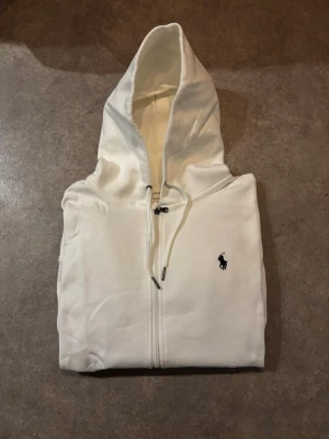 Polo Ralph Lauren Zip | Strl S - Snygg och tidlös zip hoodie från Polo Ralph Lauren i klassisk vit färg. 🤩 Mörkblå broderad logga på bröstet.  ✅Storlek S, och är i nyskick ✅Perfekt basic som funkar året runt