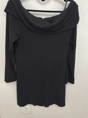 Svart klänning Gina Tricot XL - Svart klänning från Gina Tricot i storlek XL. Klänningen har en bred, nedvikt krage och trekvartsärm. Enkel och stilren design som passar till många tillfällen. Tillverkad i ett mjukt, stretchigt material.