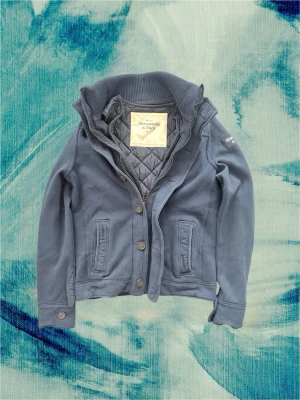 Cardigan Abercrombie & Fitch - Säljer denna sjukt feta och unika Abercrombie plagget i stl L! Den har en avtagbar väst som har knappar den sitter ihop med. Väldigt eftertraktad och sjukt unik så denna är en one of one. Passar sjukt bra till våren och sommaren. Hör av dig! Är 190 och väger 80 kg