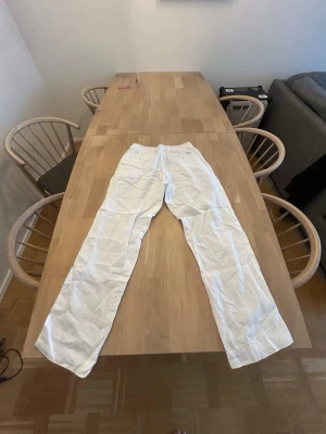 Vita linnebyxor  - Säljer ett par vita linnebyxor med loose passform och resår i midjan. Byxorna är tunna och luftiga, perfekta för varma dagar. Inga synliga detaljer eller loggor. Passar dig som gillar en clean och enkel stil.