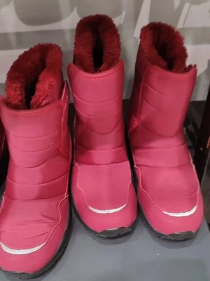 Rosa moon boots med fuskpälsfoder - Säljer ett par rosa moon boots med mjukt fuskpälsfoder och breda kardborreband. Skorna har en chunky sula i svart och är tillverkade i ett vattenavvisande material. Perfekta för kalla vinterdagar när du vill hålla fötterna varma och snygga.