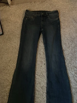Lågmidjade & bootcut jeans - Ett par blåa lågmidjade & bootcut/flare jeans från H&M! Mycket bra skick och använda fåtal ggr. 💕 Strl Xs/S, priset går att ändra.