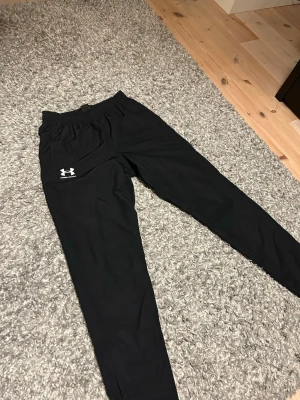 Svarta mjukisbyxor från Under Armour - Svarta Byxor från Under Armour i storlek M. Säljer eftersom dom inte används och samlar damm. Byxorna är riktigt fina och knappast använda. Om du har frågar så är det bara att ställa dom