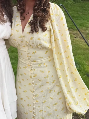 Adoore klänning gul/blommig - Långklänning i ljusgul nyans med små blommor från Adoore. 